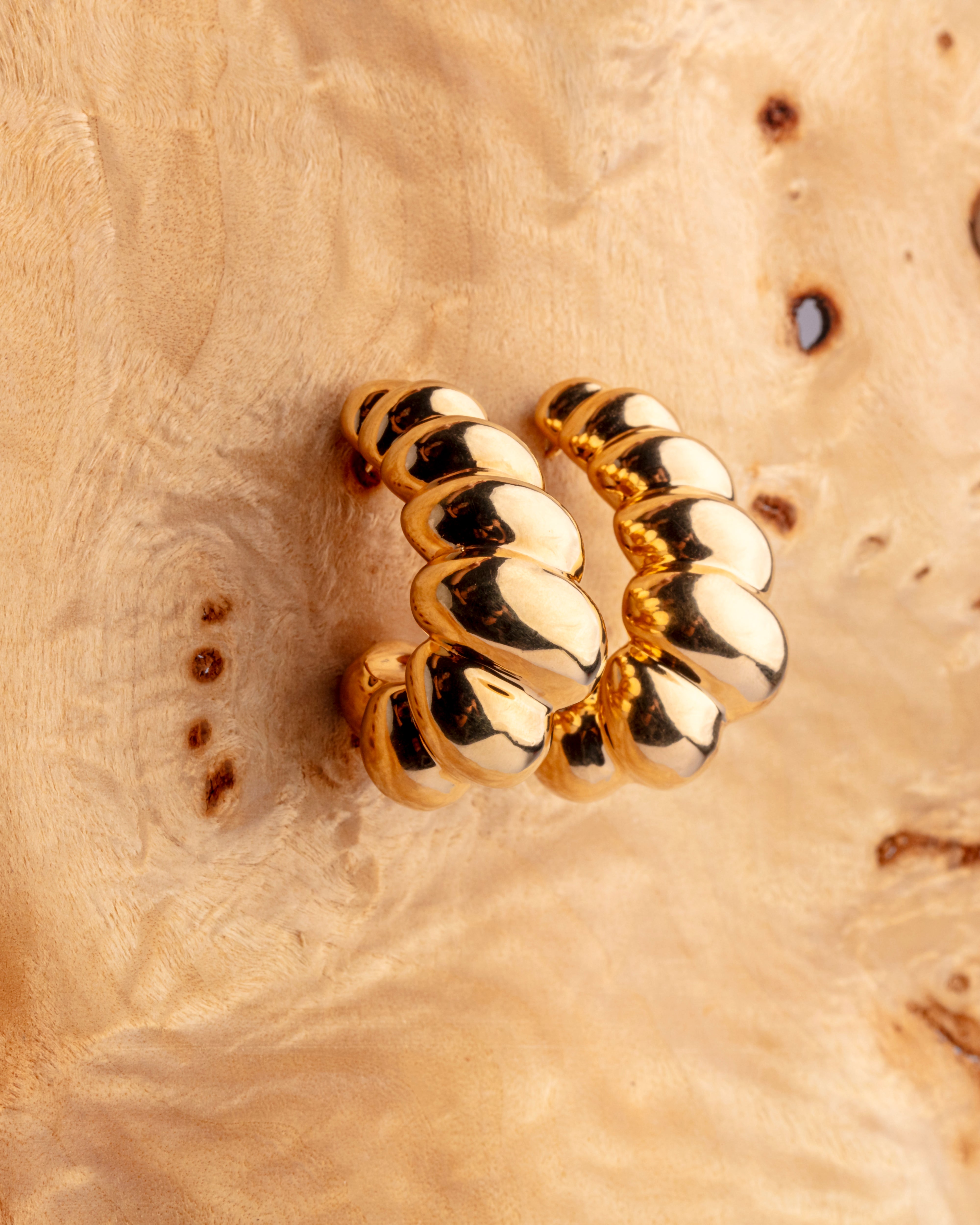 Gold plated chunky hoop earrings with bold circular design and smooth polished finish