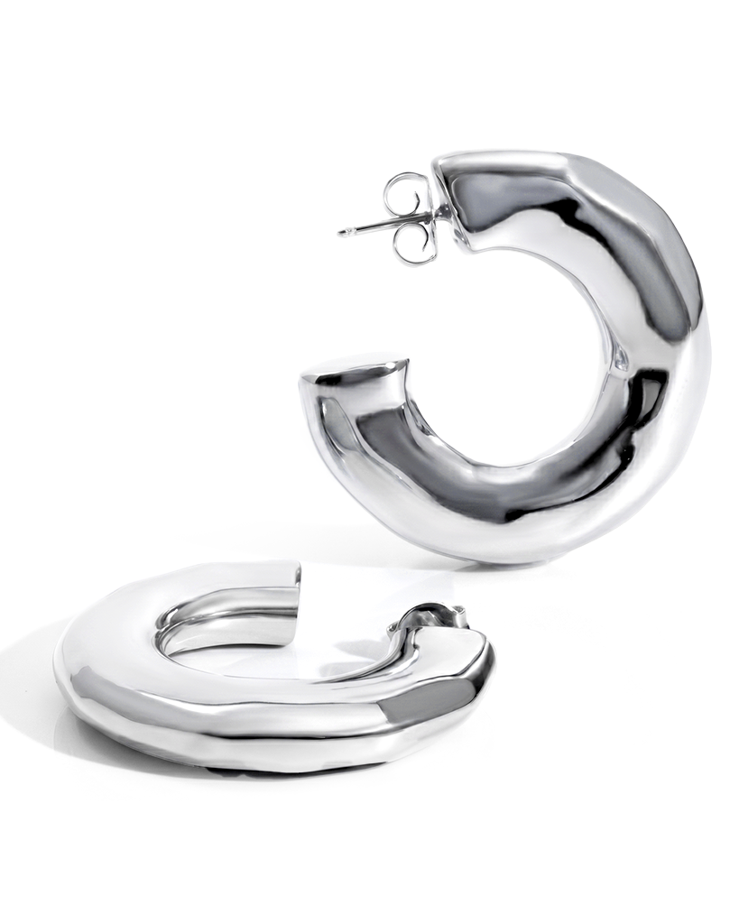 Hammered open hoop earrings available in gold plated and rhodium plated finishes with sculptural texture