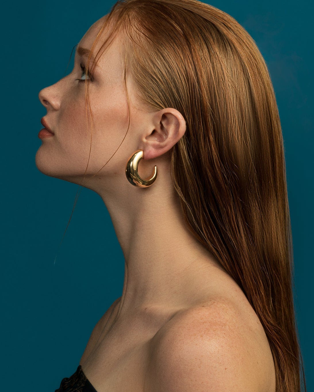 Large gold plated hoop earrings with thick sculptural curved design and polished finish, 38mm diameter