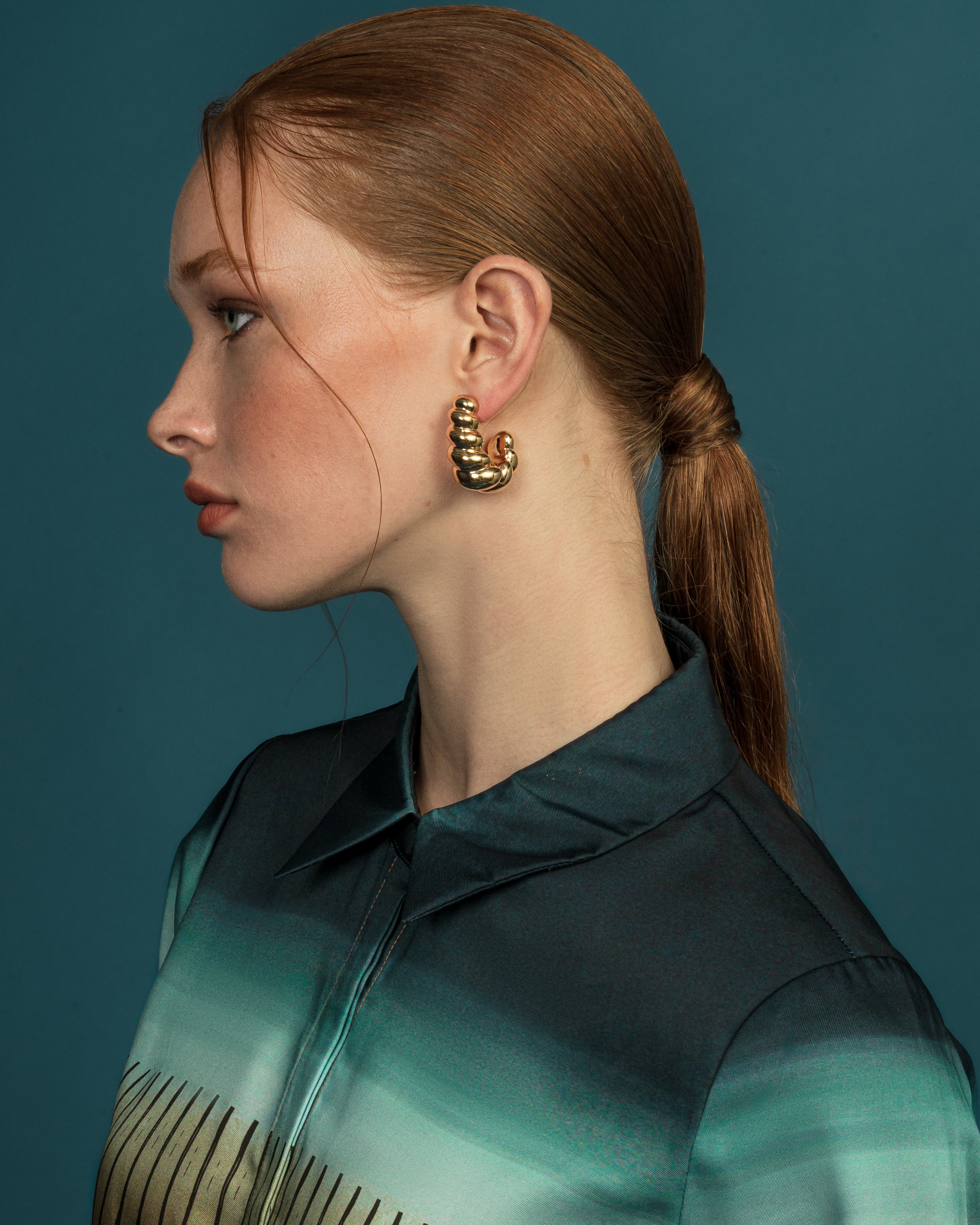 Model wearing Catarina gold sculptural earrings