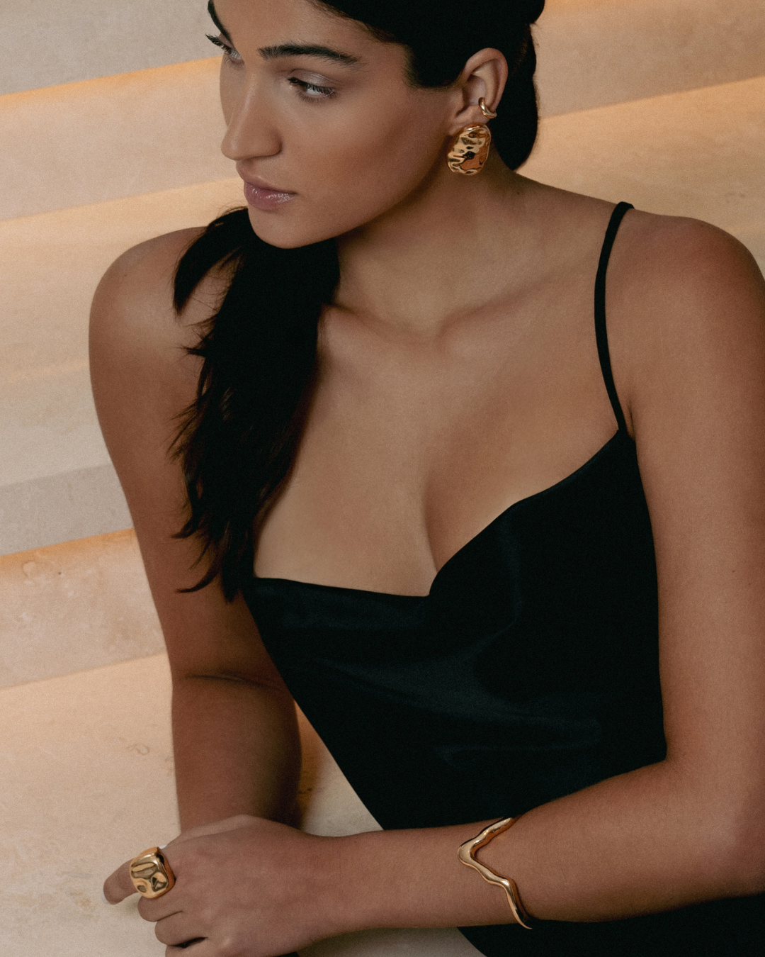 Gold oval sculptural earrings with smooth curved design and polished finish