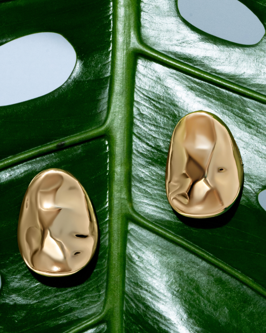 Gold oval sculptural earrings with smooth curved design and polished finish