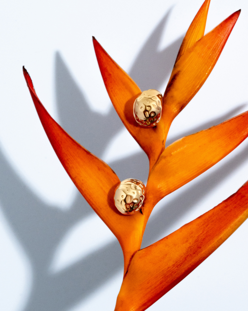 Gold sculptural earrings with compact organic texture and polished finish