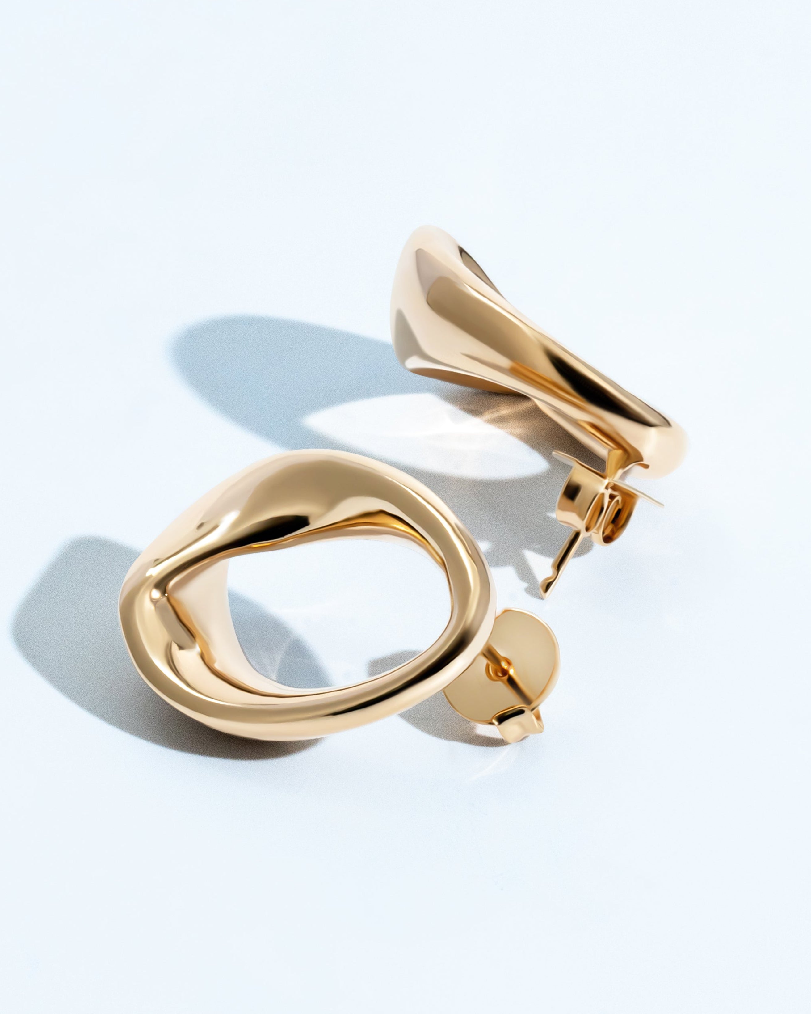 Abstract oval earrings available in gold plated and rhodium plated finishes with sculptural geometric design
