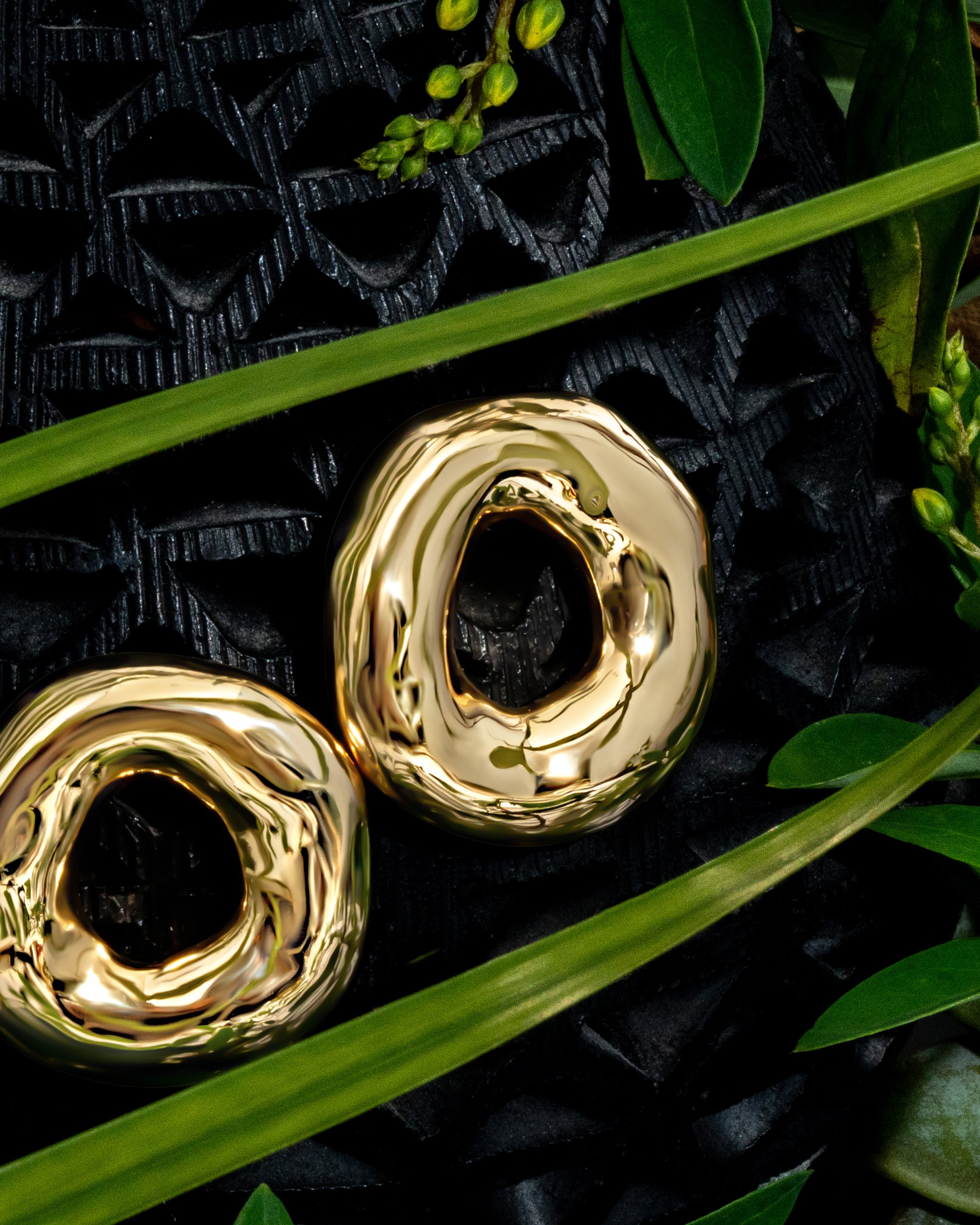 Melted circle earrings available in gold plated and rhodium plated finishes with sculptural curved design