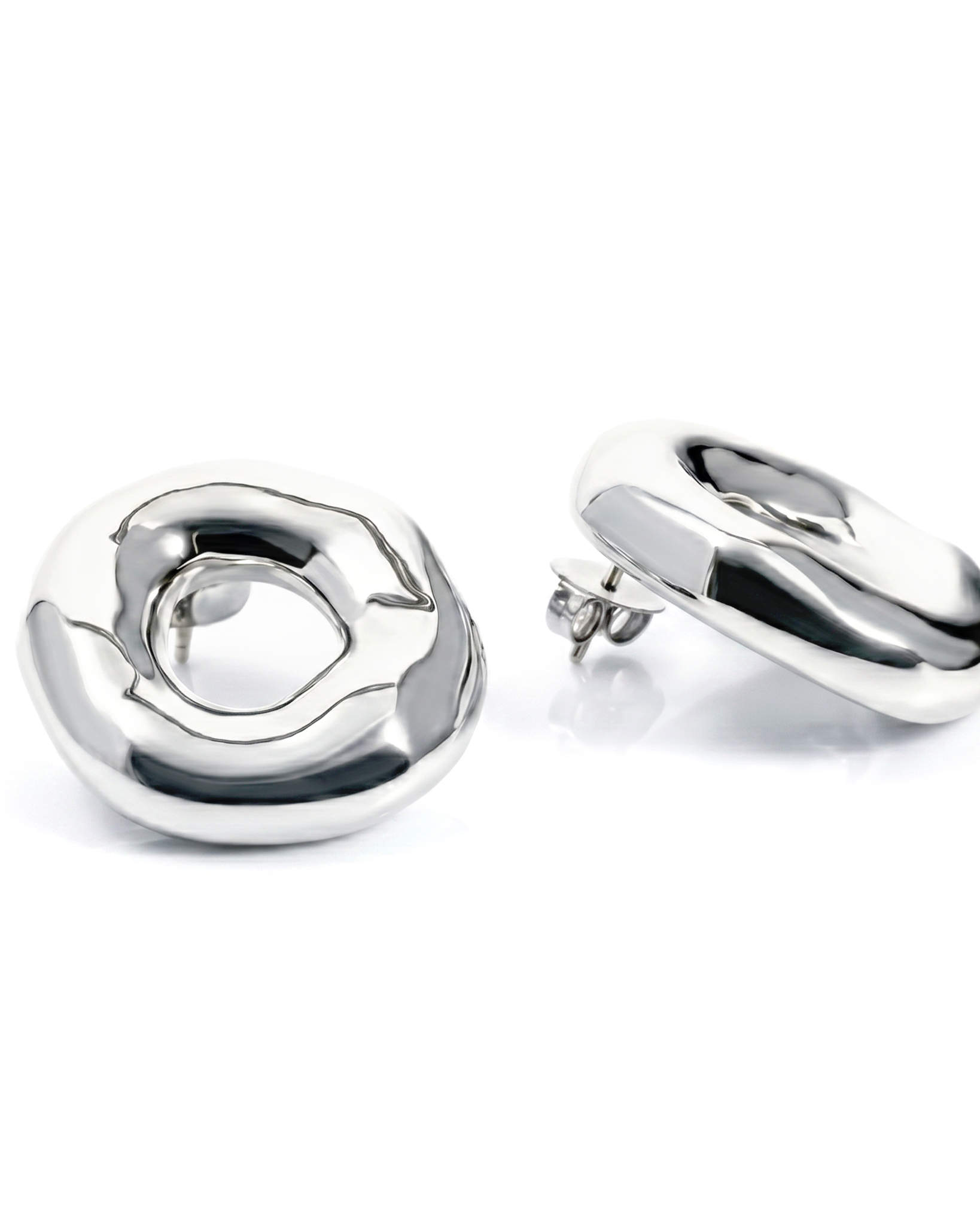 Melted circle earrings available in gold plated and rhodium plated finishes with sculptural curved design