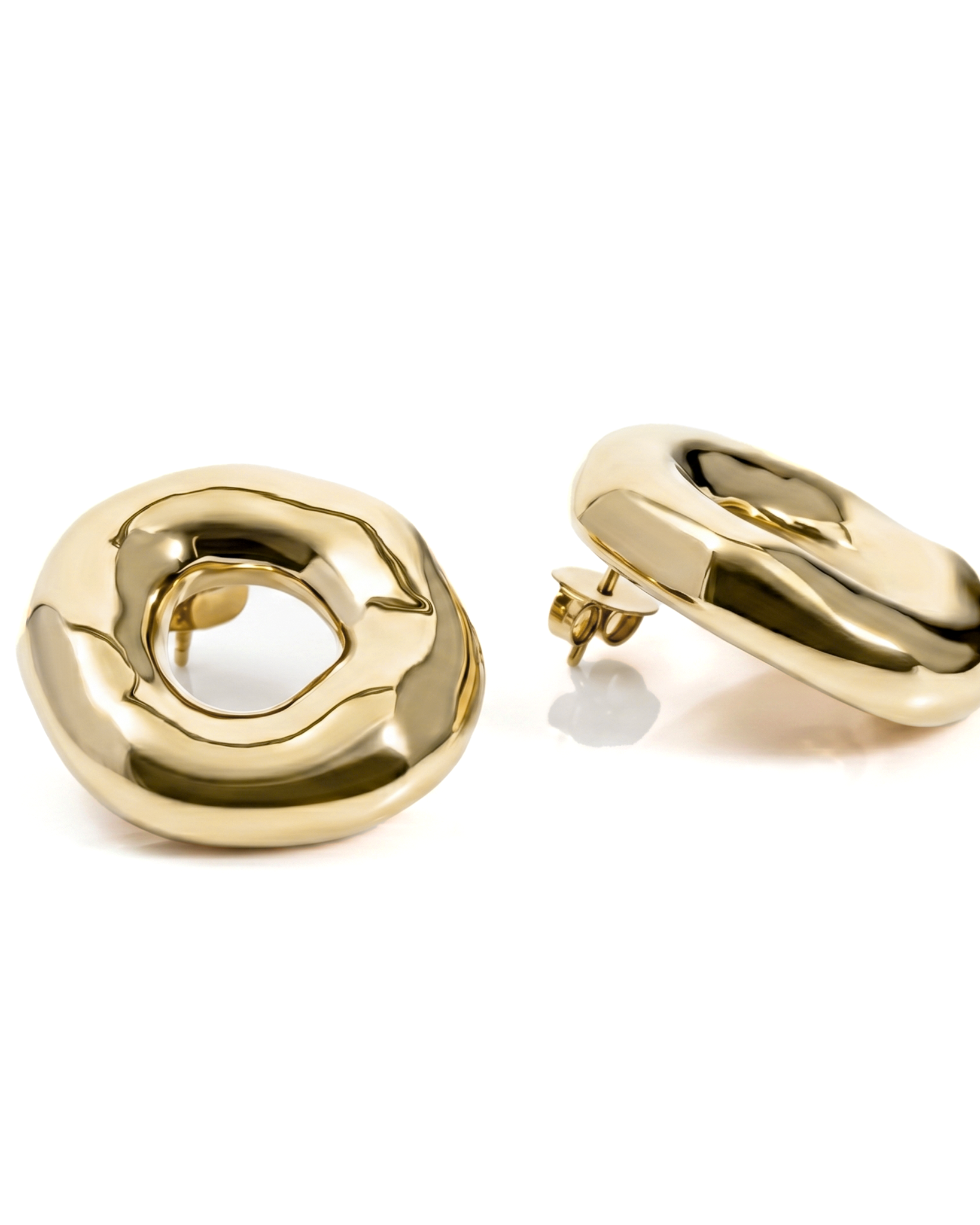 Melted circle earrings available in gold plated and rhodium plated finishes with sculptural curved design