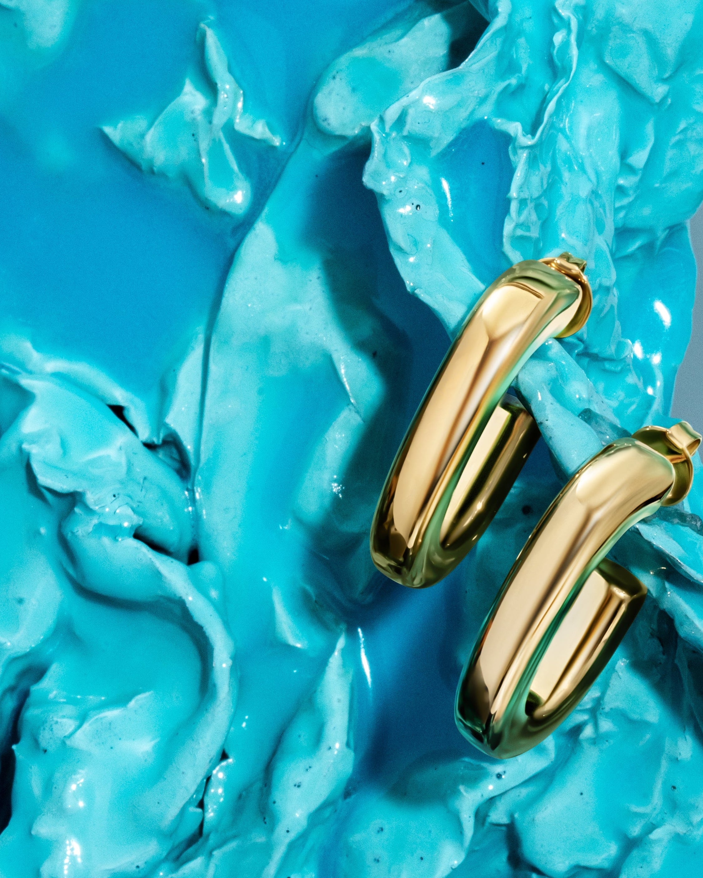 Oval open hoop earrings available in gold plated and rhodium plated finishes with sculptural curved design