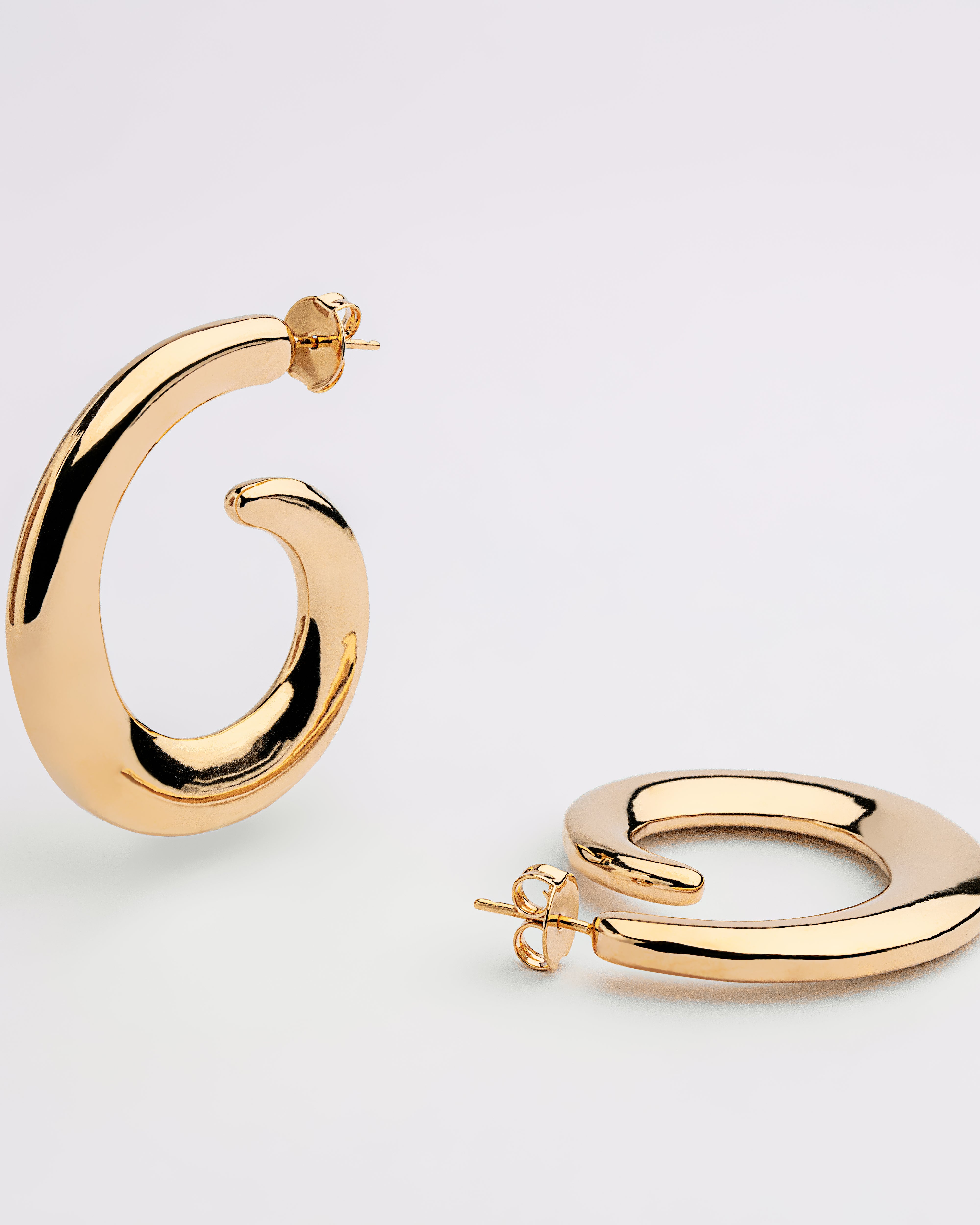 Gold plated loop dangle earrings with fluid curved design and polished finish