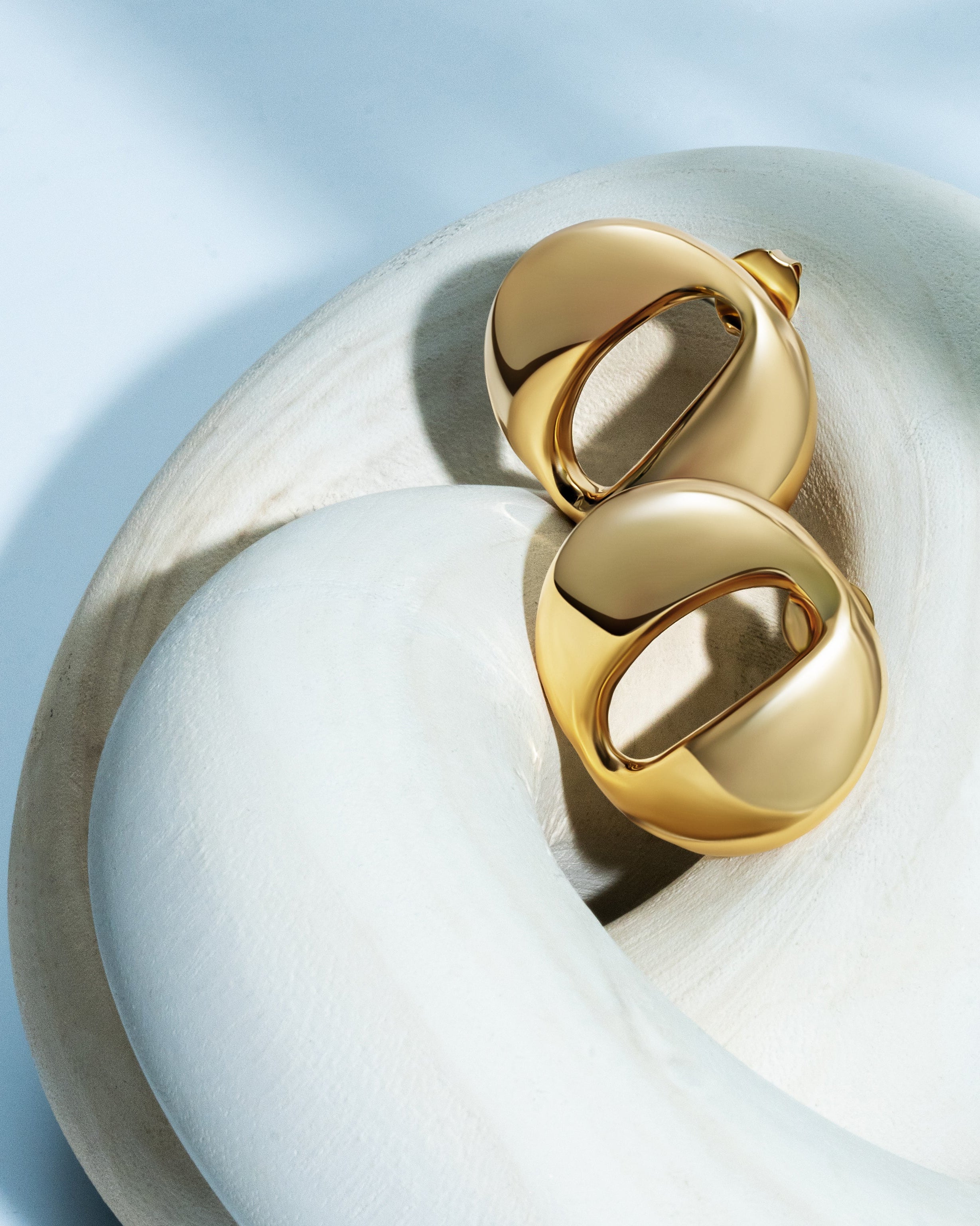 Dome earrings available in gold plated and rhodium plated finishes with smooth sculptural design