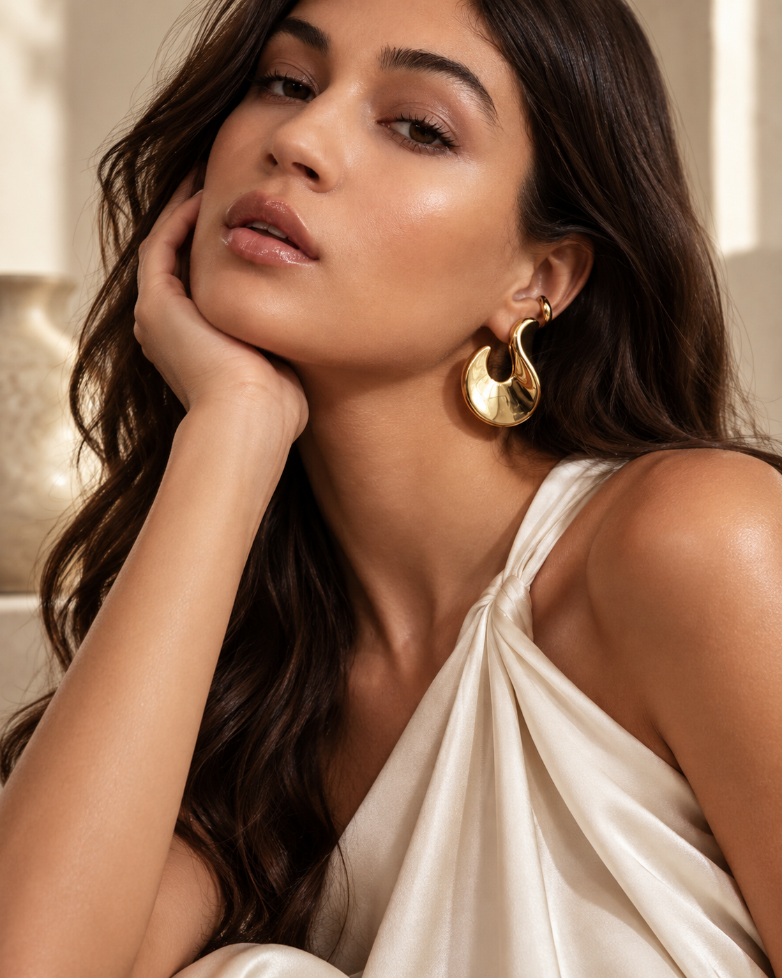 a model wearing a Sculptural flame gold statement earrings
