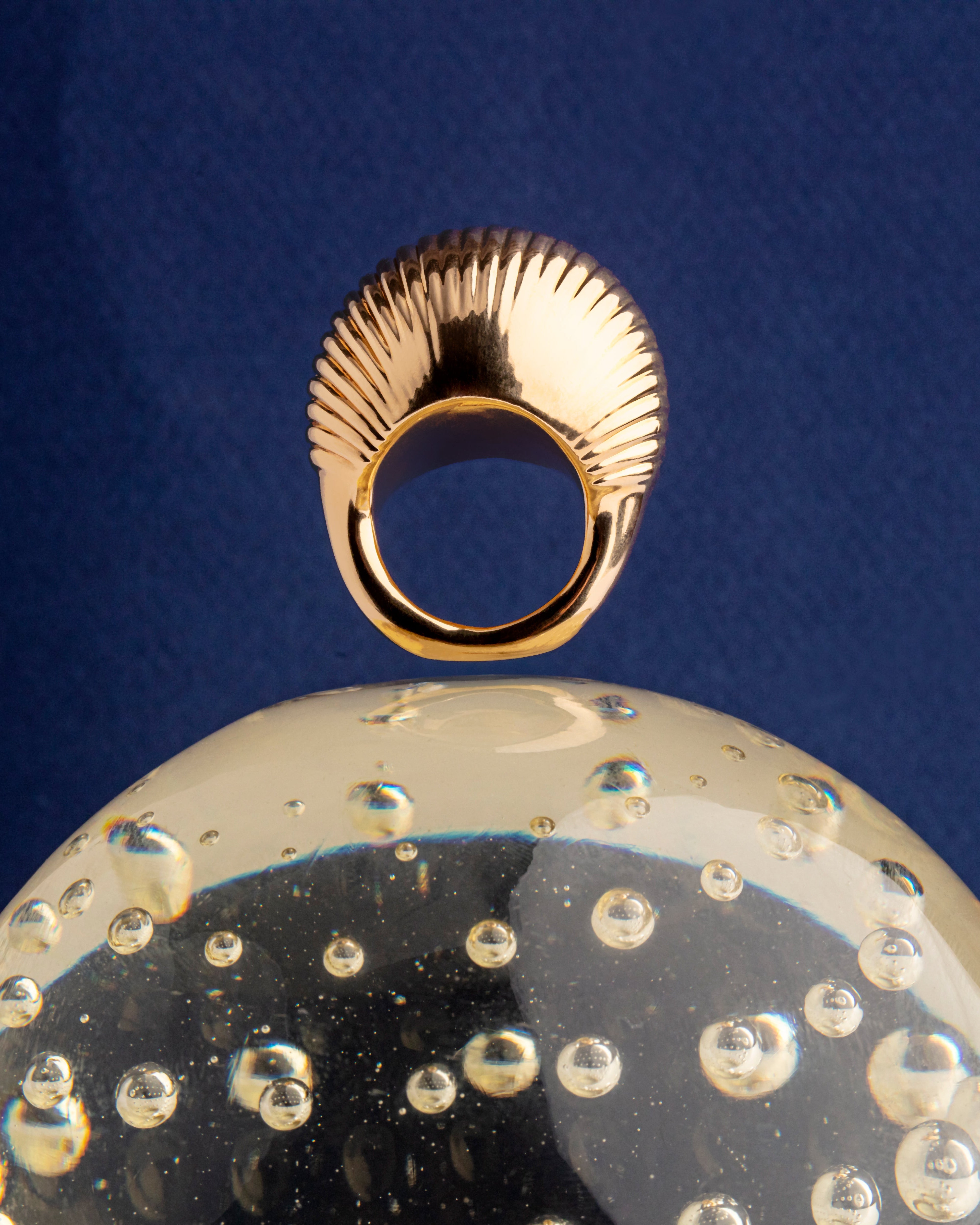 Gold plated bold sculptural ring with solid form and polished finish