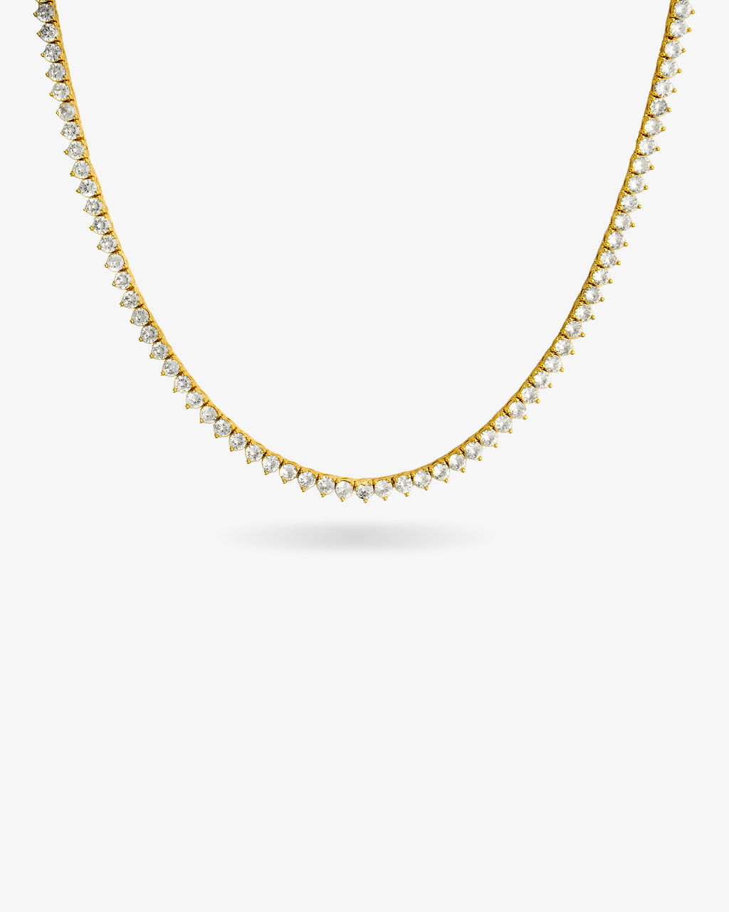 Gold three-prong tennis necklace with simulated diamond stones, alone product shot on a plain background.