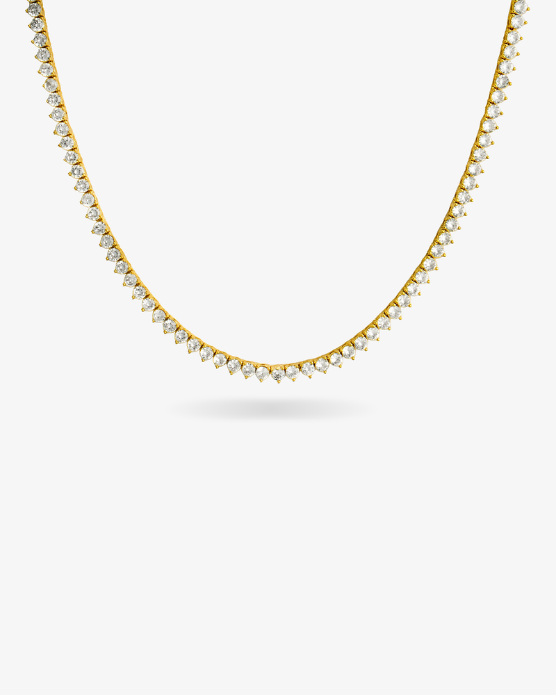 Gold three-prong tennis necklace with simulated diamond stones, alone product shot on a plain background.