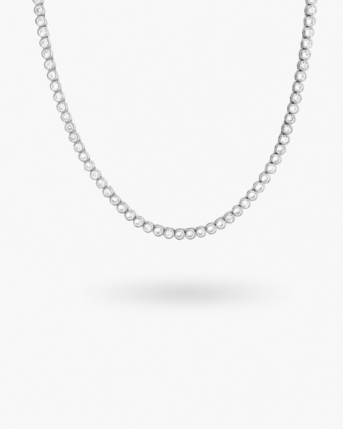 Silver round bezel-set tennis necklace, alone product shot on a plain background.