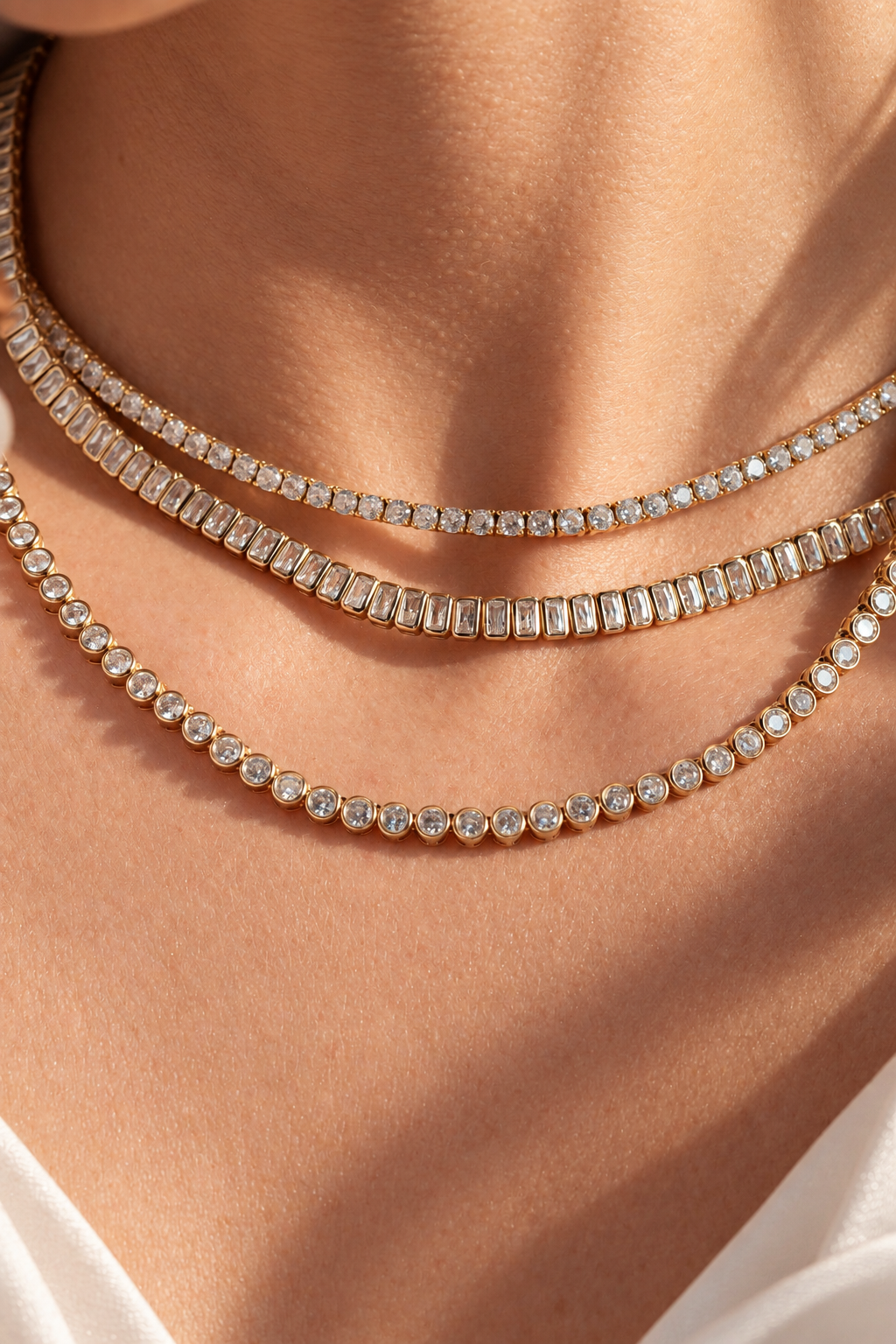 Close-up of a neckline layered with two Cynthia round-cut tennis choker necklaces
