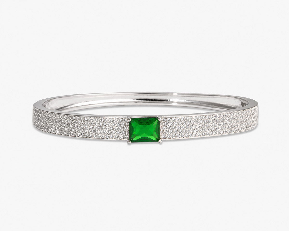 Gold pave bangle bracelet with a single blue simulated diamond stone, alone product shot on a plain background.