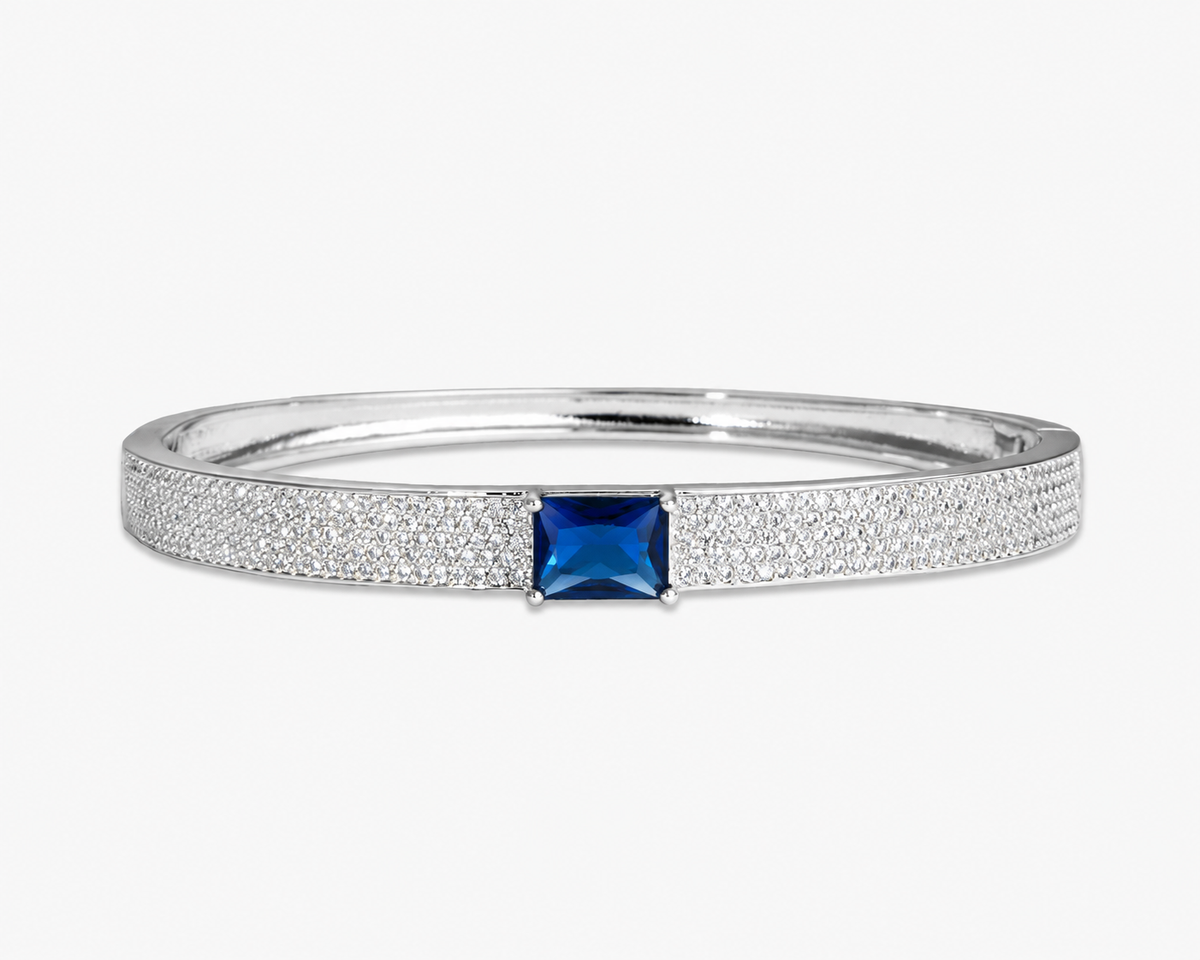 Gold pave bangle bracelet with a single clear simulated diamond stone, alone product shot on a plain background.