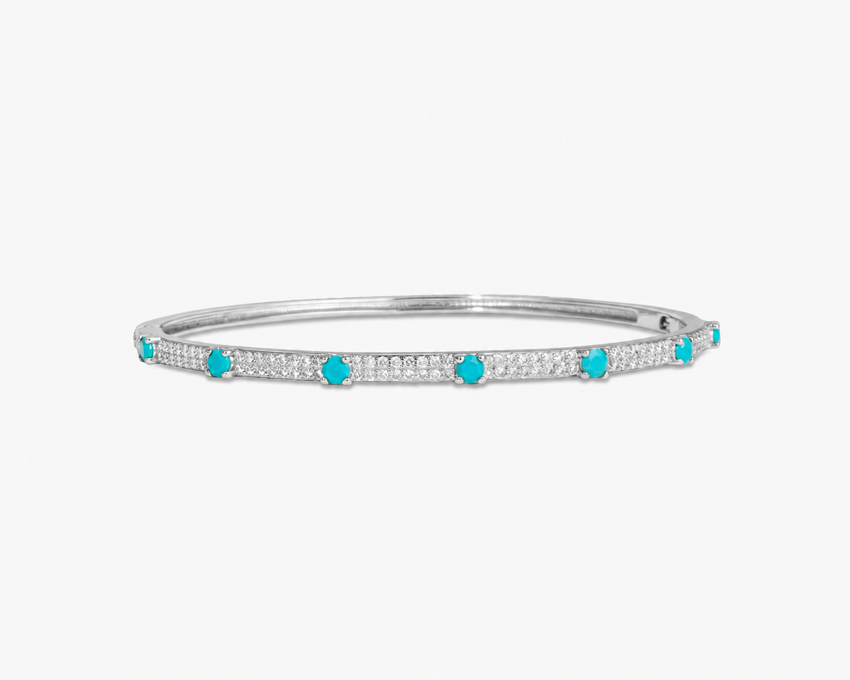 Silver thin bangle bracelet with green simulated diamond stone detailing, alone product shot on a plain background.