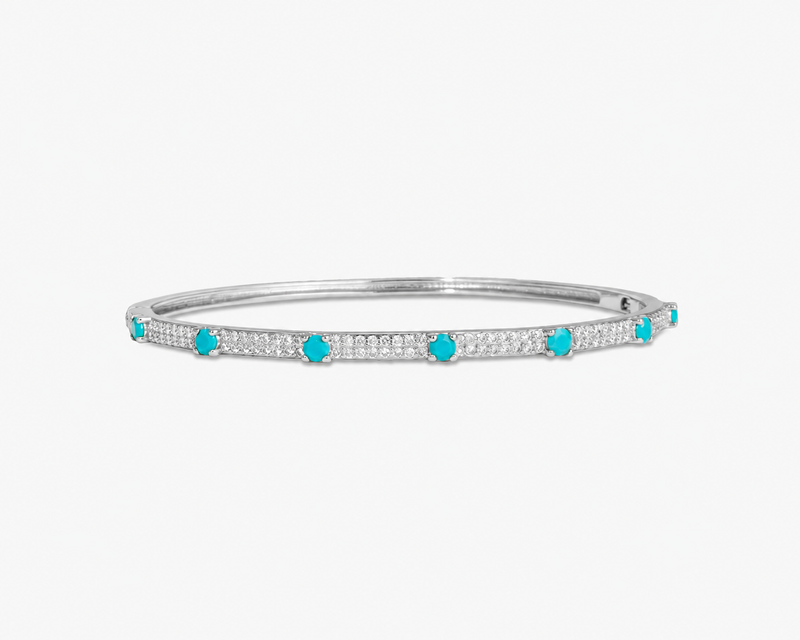 Silver thin bangle bracelet with green simulated diamond stone detailing, alone product shot on a plain background.