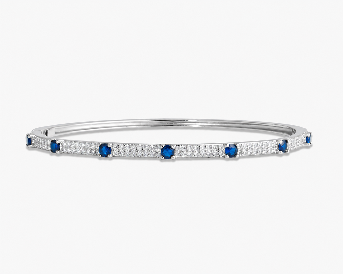 Silver thin bangle bracelet with pink simulated diamond stone detailing, alone product shot on a plain background.