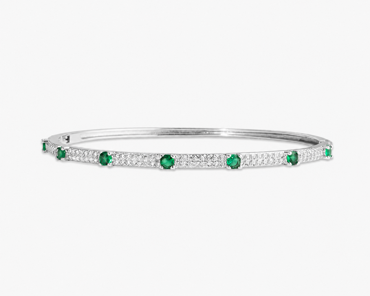 Silver thin bangle bracelet with blue simulated diamond stone detailing, alone product shot on a plain background.