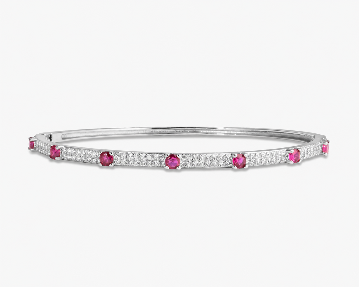 Silver thin bangle bracelet with teal simulated diamond stone detailing, alone product shot on a plain background.