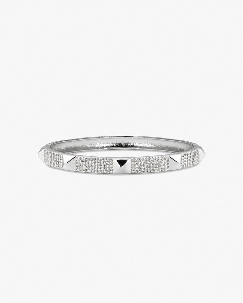 Silver textured bangle bracelet, alone product shot on a plain background.