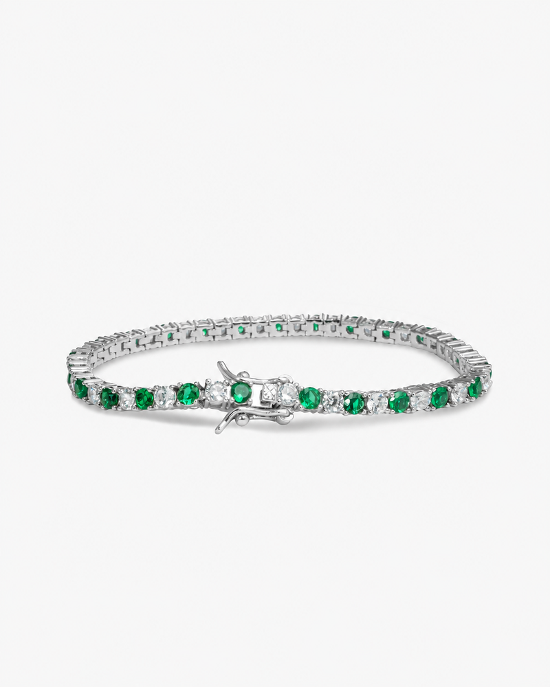 Silver tennis bracelet with green colored stone detailing, alone product shot from a different angle.