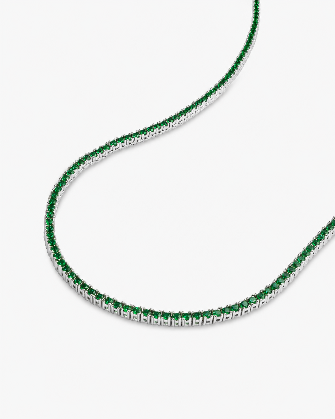 Silver tennis necklace with multicolor simulated diamond stones, alone product shot laid in a curved squiggle shape, from a different angle.