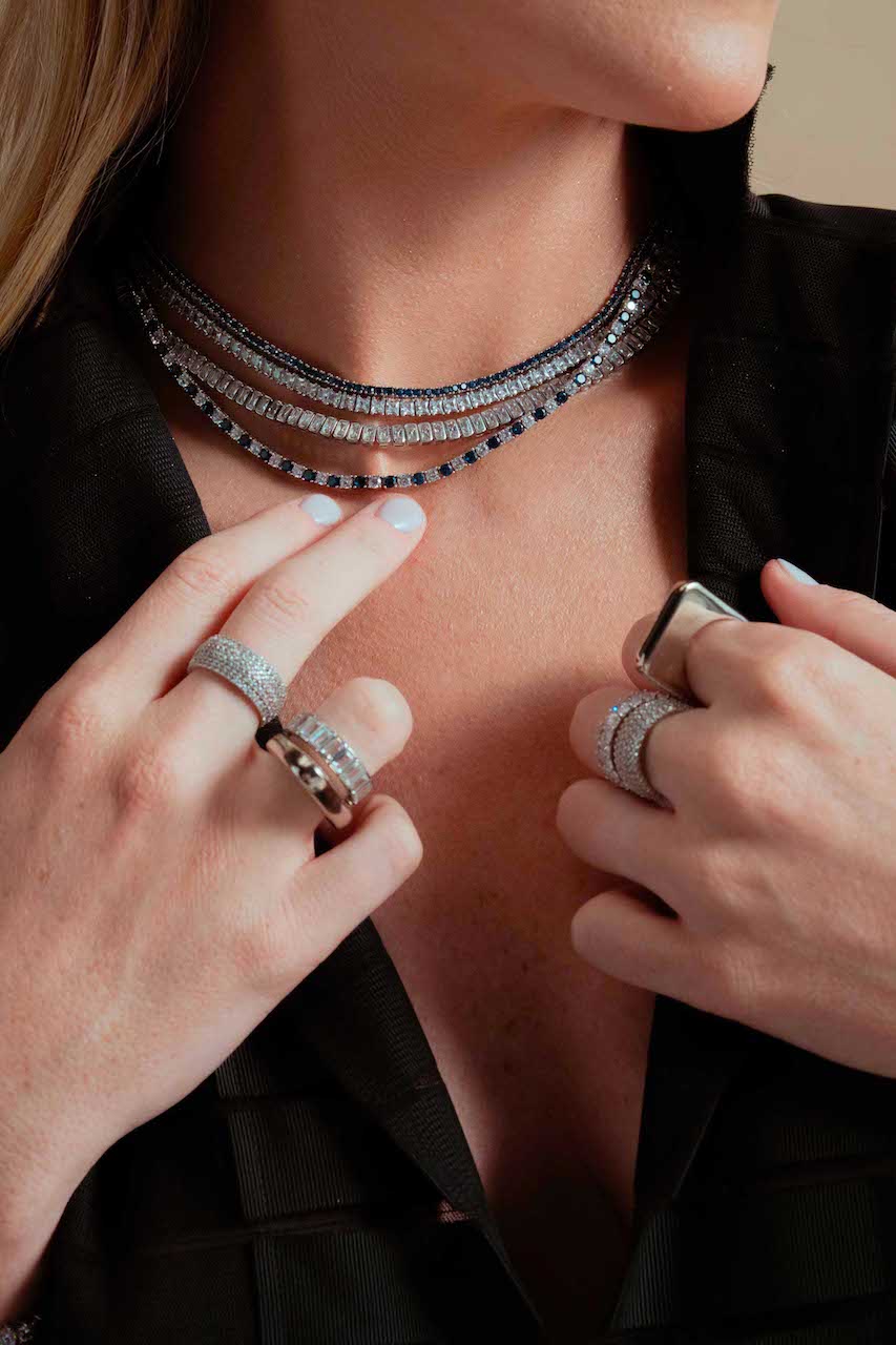 Close-up of a neckline and collar, dark top, wearing delicate jewelry