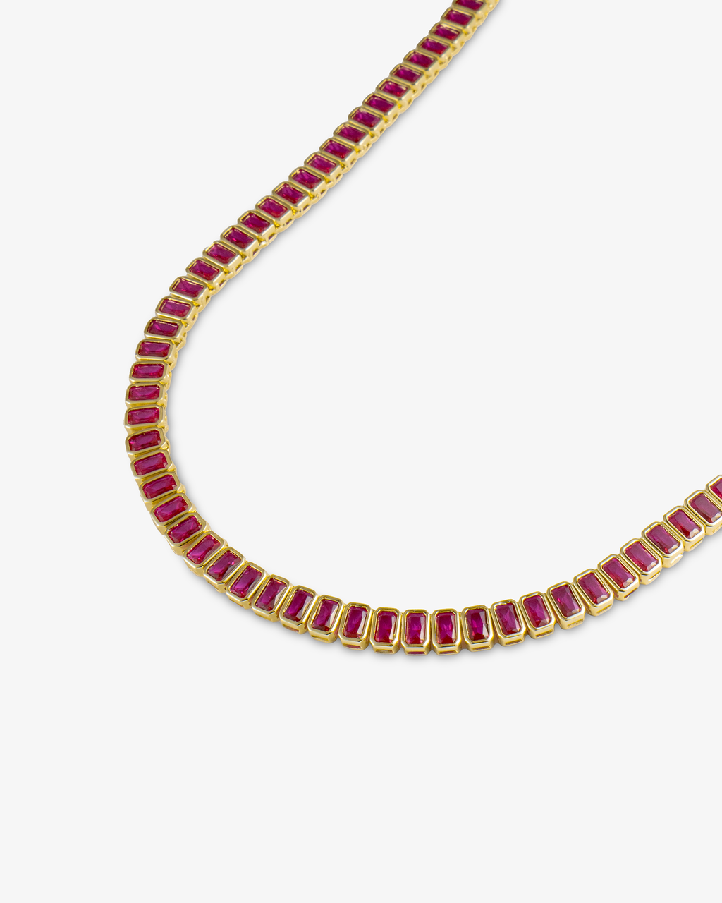 Gold tennis necklace with red baguette-cut simulated diamond stones, alone product shot from a curved angle.