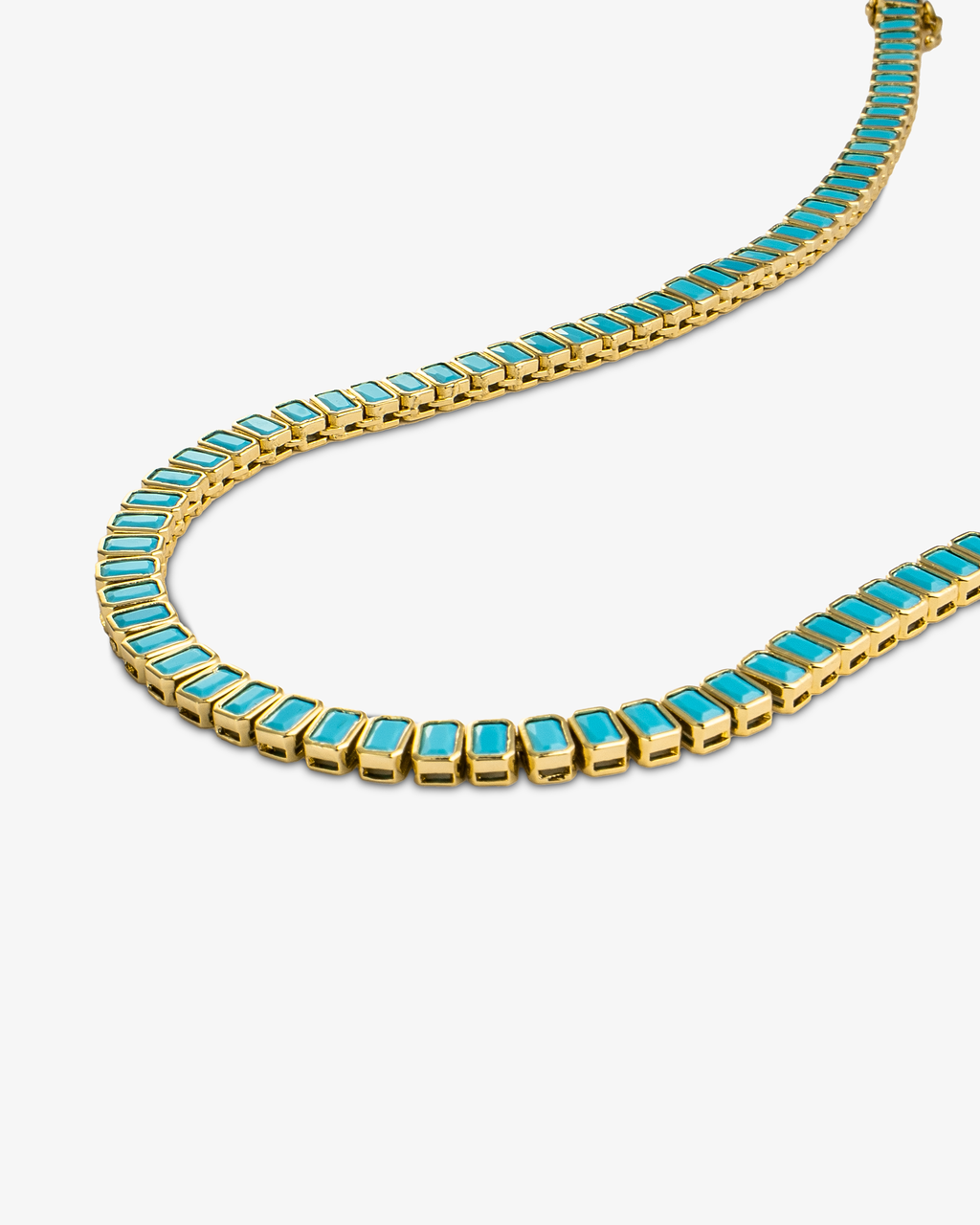 Gold tennis necklace with teal baguette-cut simulated diamond stones, alone product shot from a curved angle.