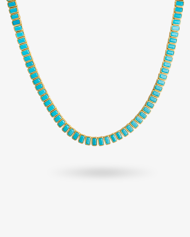 Gold tennis necklace with teal baguette-cut simulated diamond stones, alone product shot on a plain background.
