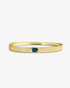 Gold textured bangle bracelet with a blue simulated diamond accent stone, alone product shot on a plain background.
