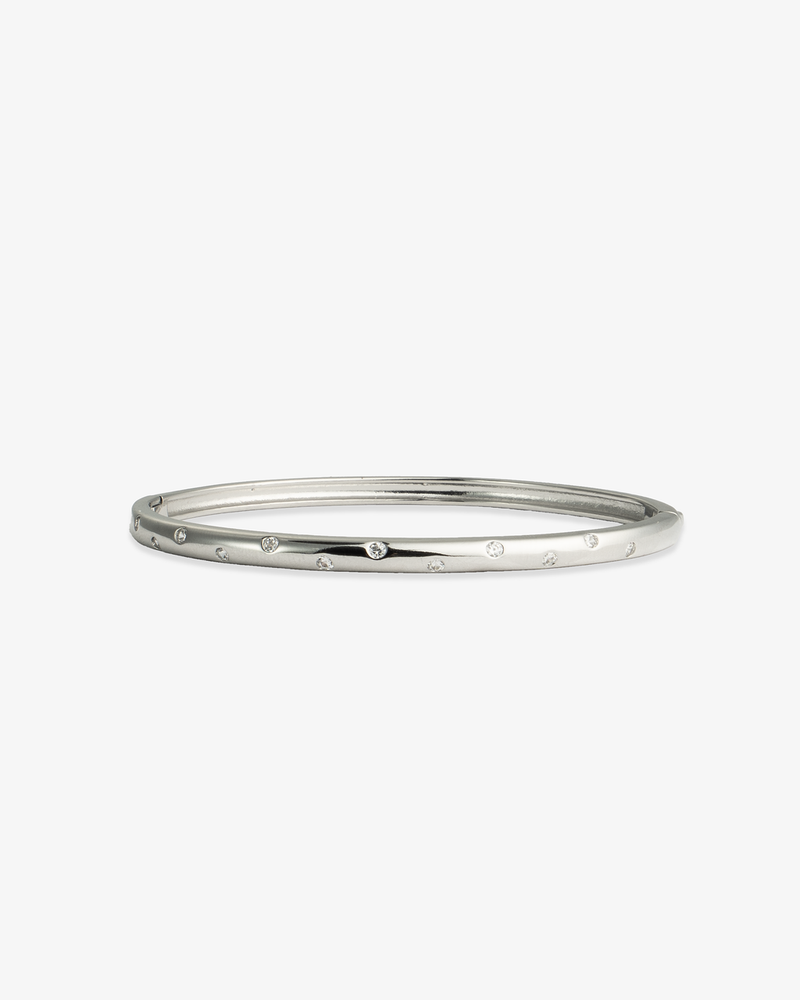 Silver slim textured bangle bracelet, alone product shot on a plain background.