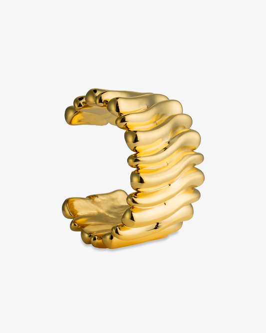 Gold chunky sculptural wavy open cuff bracelet, close-up alone product shot of the ridged texture.