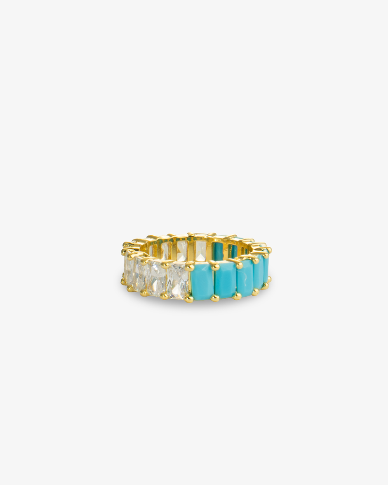Gold eternity band ring with turquoise simulated diamond stones, alone product shot on a plain background.