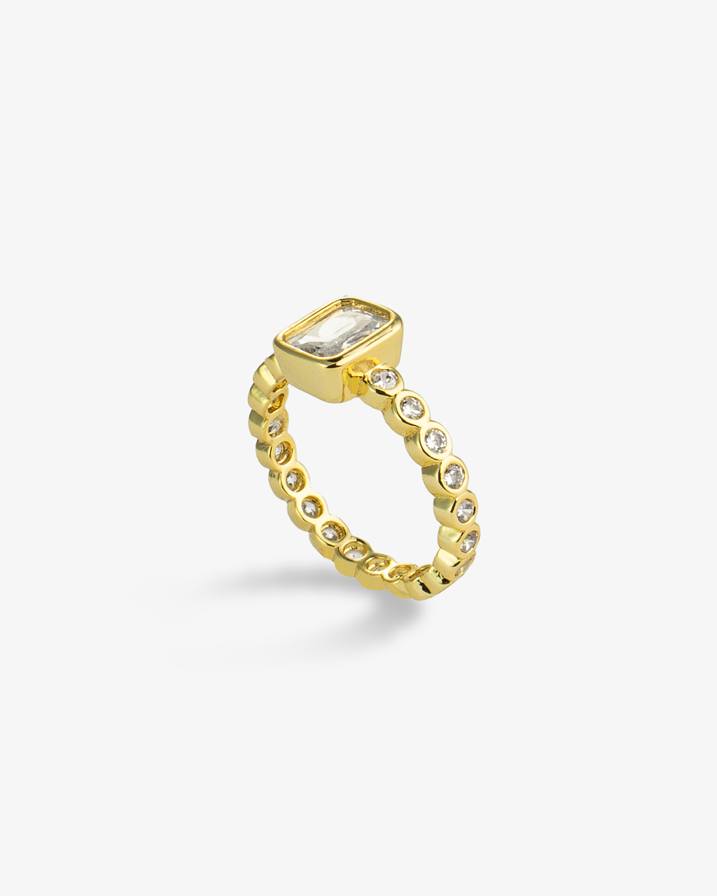 Gold ring with a clear emerald-cut simulated diamond center stone and pave band, alone product shot from a different angle.