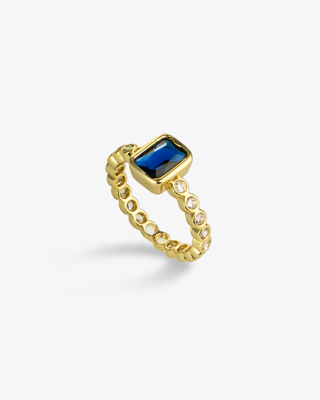 Gold ring with a blue emerald-cut simulated diamond center stone and pave band, alone product shot on a plain background.
