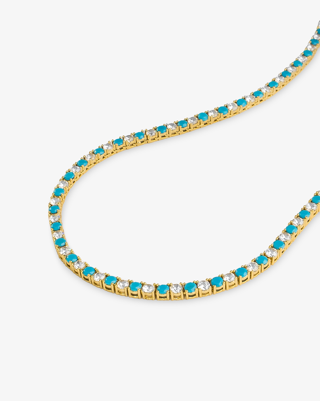 Tennis necklace with turquoise-colored simulated diamond stones, alone close-up product shot laid in a curved squiggle shape.
