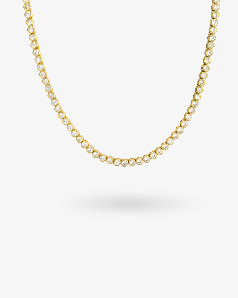 Gold round bezel-set tennis necklace, alone product shot on a plain background.