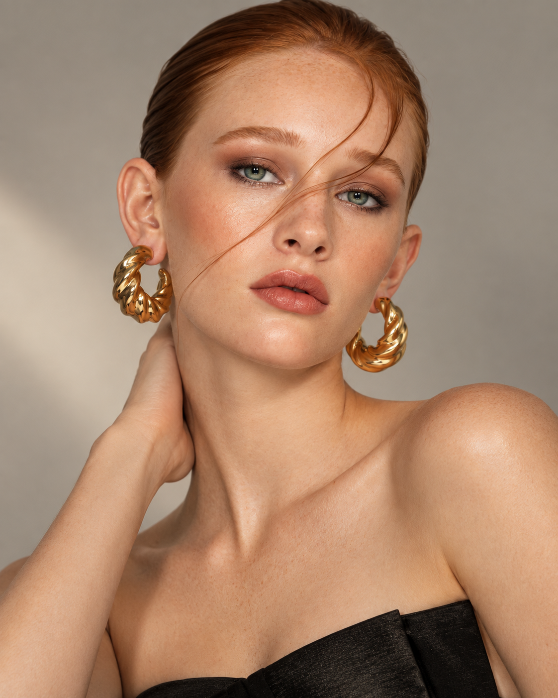 a model wearing a Chunky Twisted Sculptural Gold Hoop Earrings