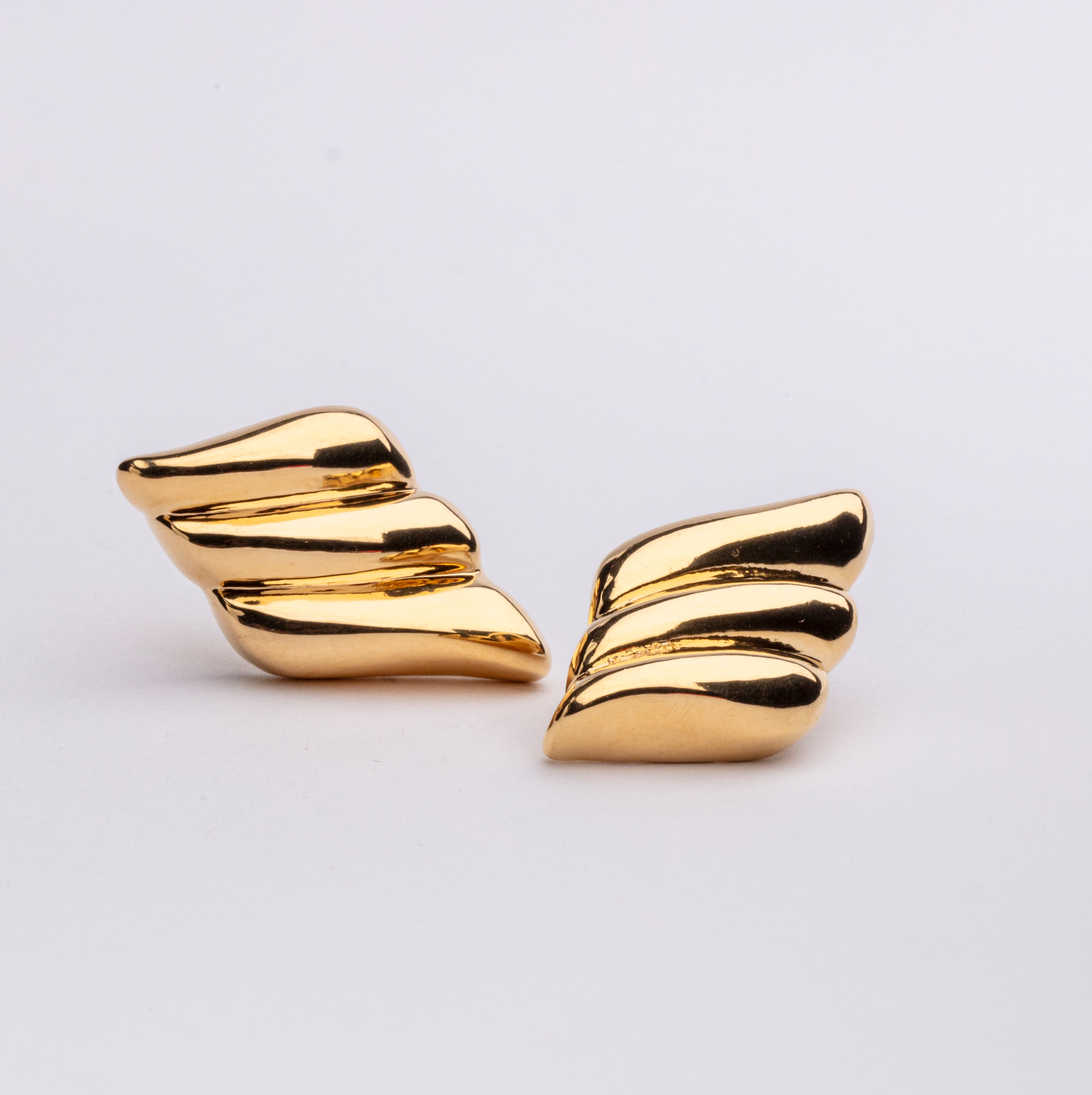 Gold plated wing-inspired earrings with sculptural curved design and elongated shape