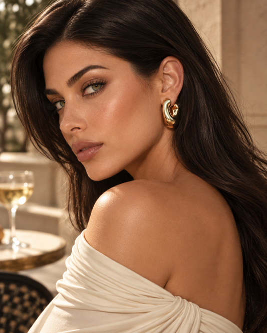 a model wearing a Chunky sculptural gold hoop earrings