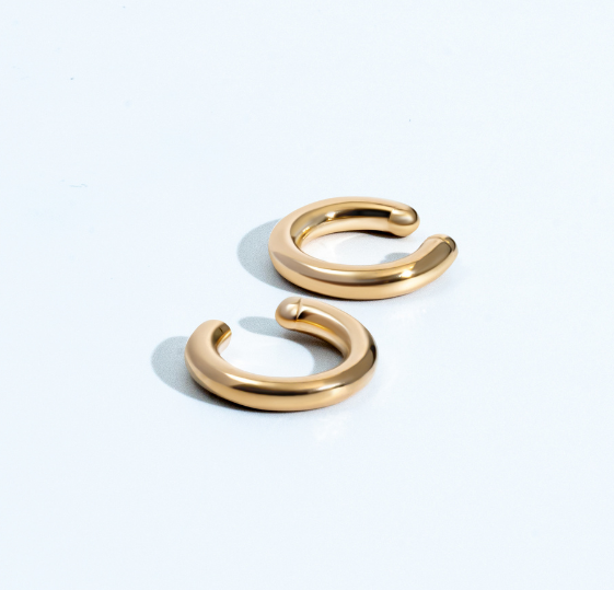 Gold circular ear cuff with minimal sculptural design and polished finish
