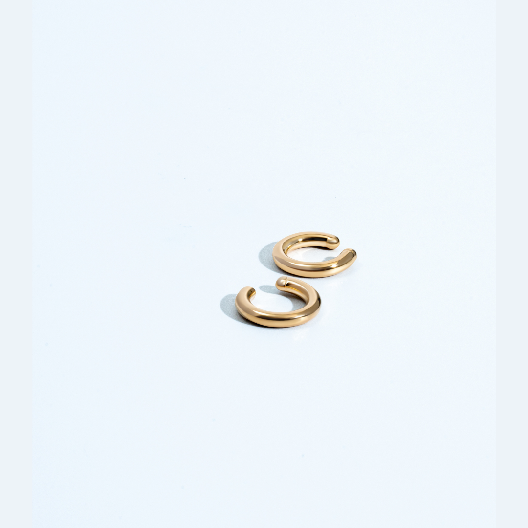 Gold circular ear cuff with minimal sculptural design and polished finish
