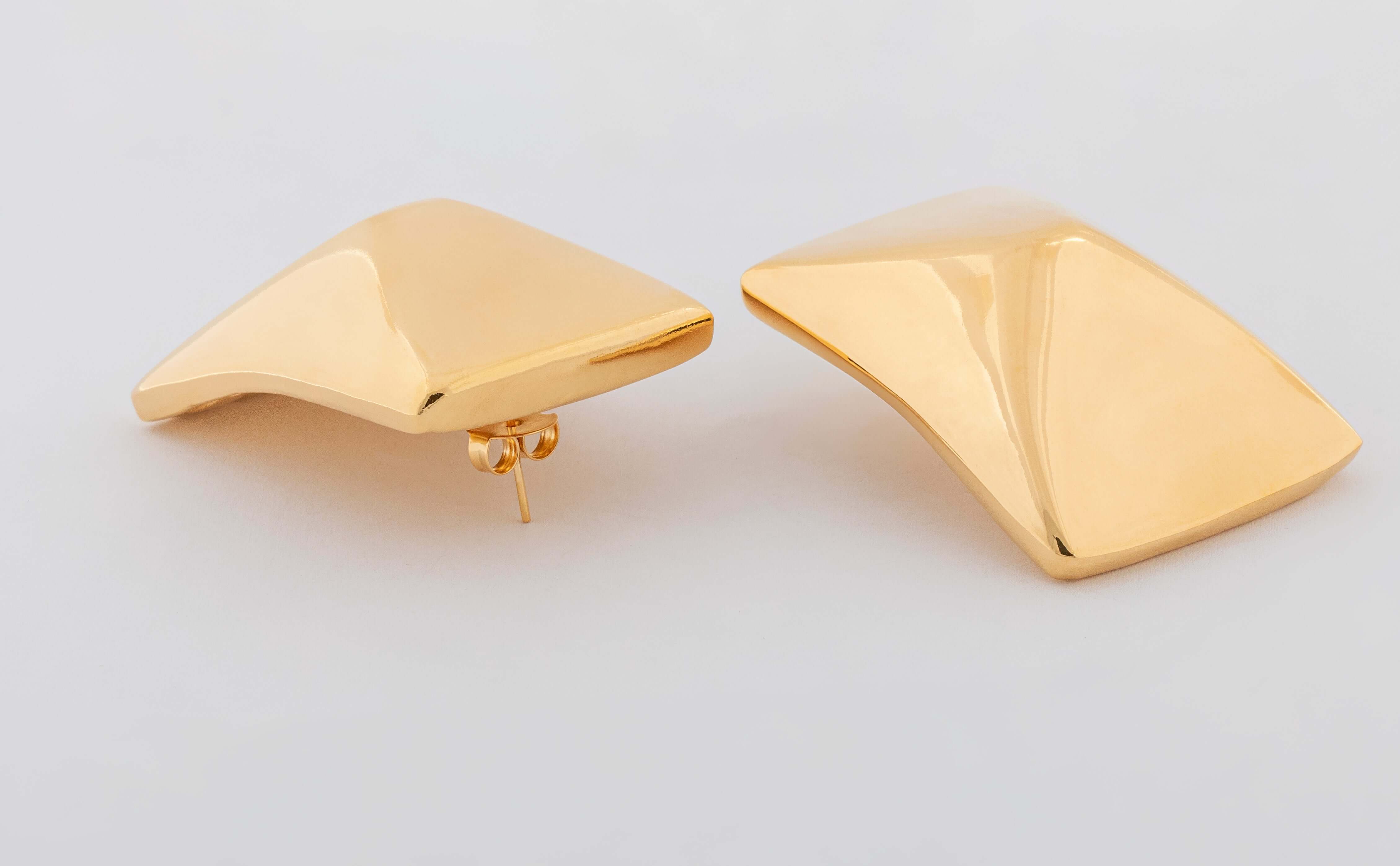 Gold plated sculptural earrings with asymmetric curved design and polished finish, 50mm by 35mm