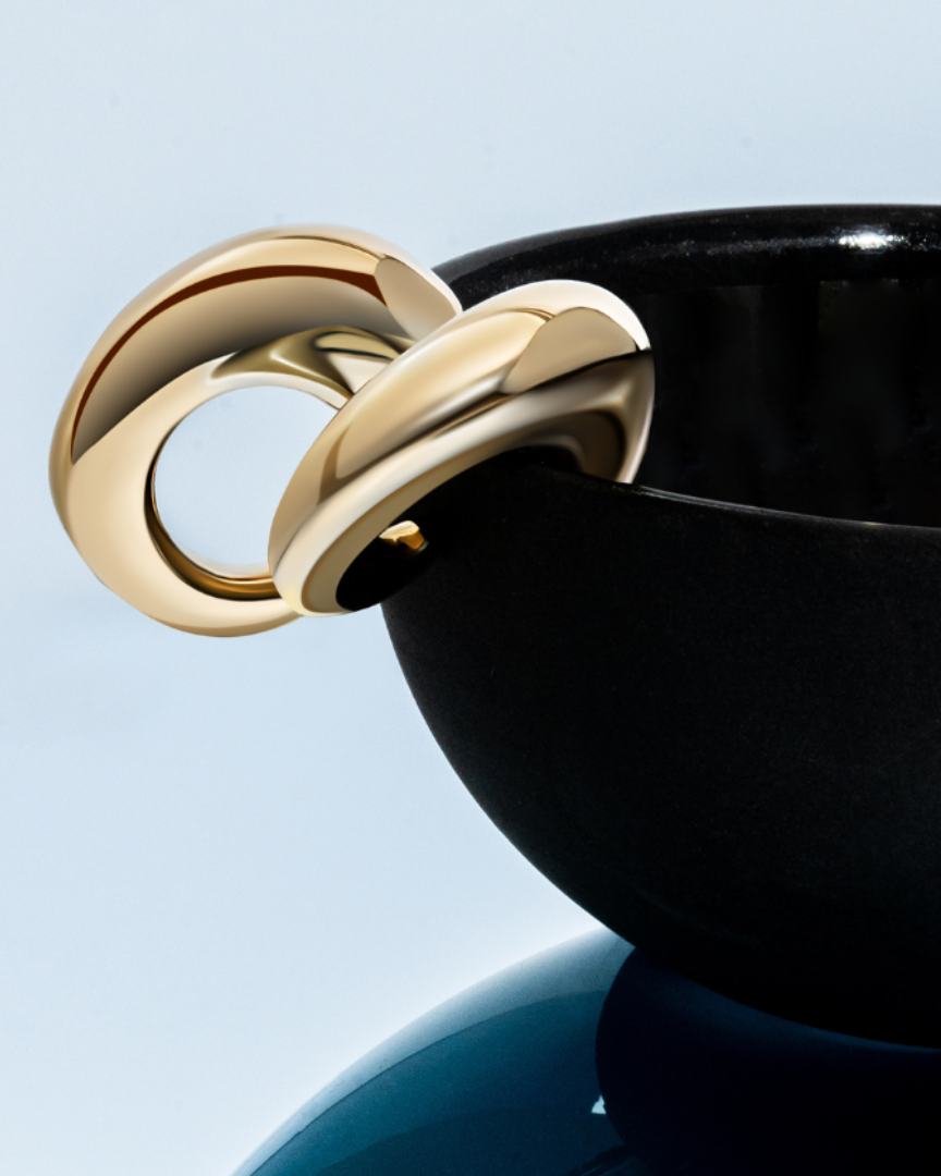 Oval open hoop earrings available in gold plated and rhodium plated finishes with sculptural thick design