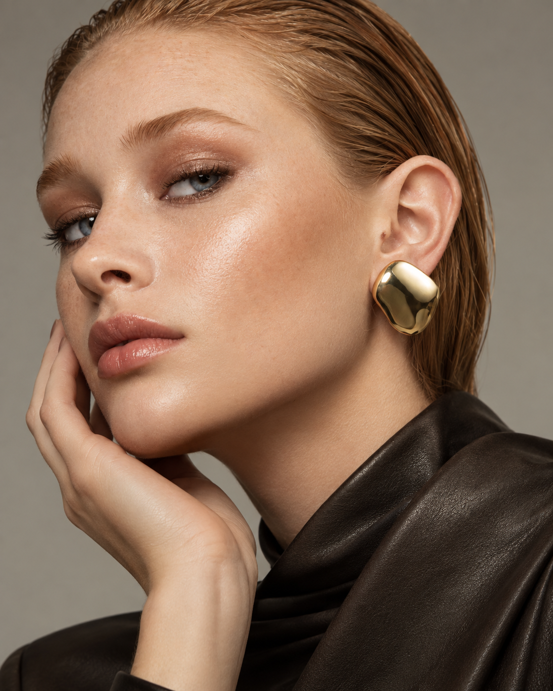 a model wearing Sculptural cushion gold statement earrings